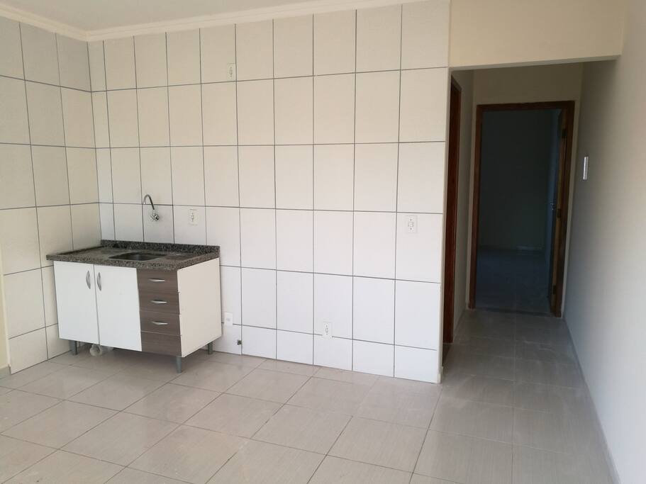 Cozinha/Sala, acesso ao quarto. Para a estadia ainda contará com um frigobar, um armário e mesa para 2 lugares.