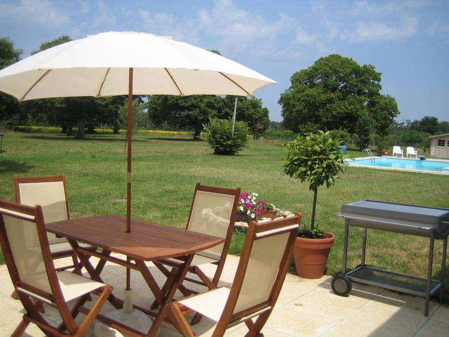 The gite - patio overlooking the pool with charcoal bbq.