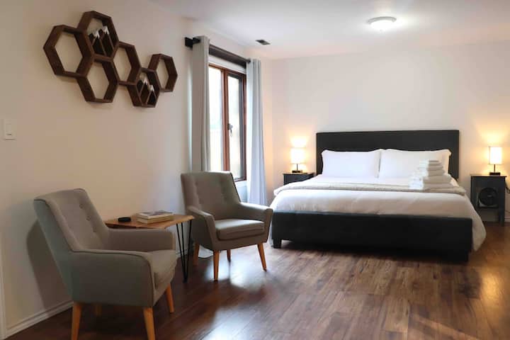 Chambre king size/chambre principale. Draps en bambou doux et serviettes de spa. Ainsi qu'une vue sur l'arrière-cour /l'espace vert depuis la fenêtre. Coin salon pour le café du matin ou la lecture du soir.