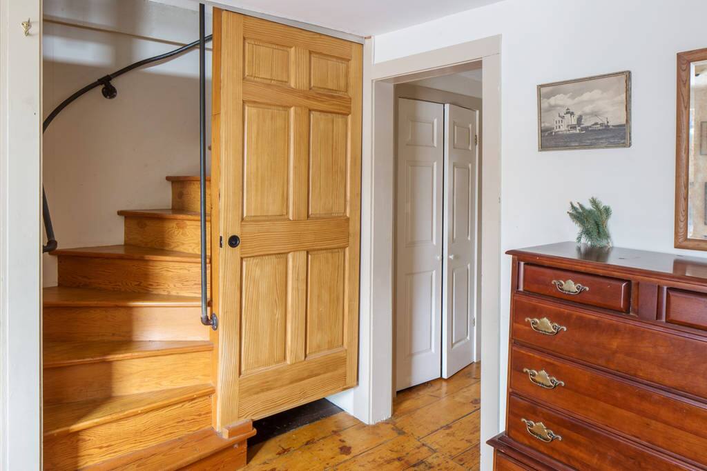 Second floor bedroom looking at the stairs up to the loft bedroom, with the room divider curtain open.