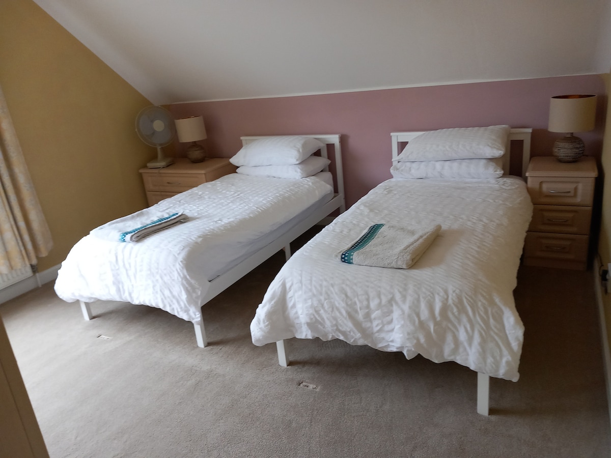 سريران مفردان مع إمكانية الوصول إلى الحمام الرئيسي