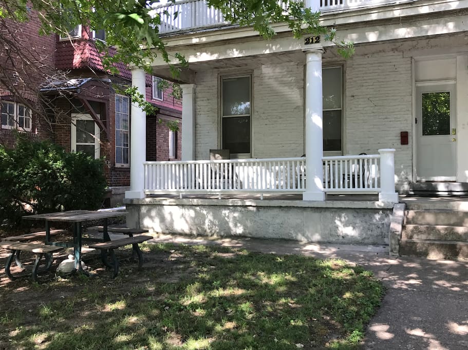 The front of the house displaying the front door, the porch, and the picnic table.
