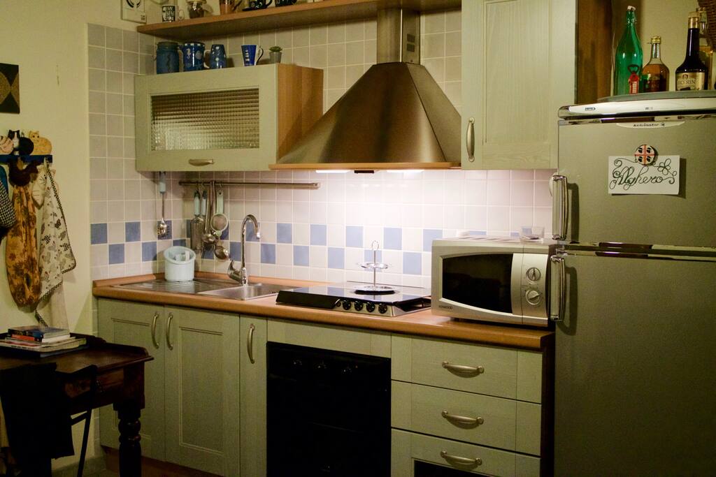 Angolo cottura con forno statico, forno a microonde, cappa e ventola.