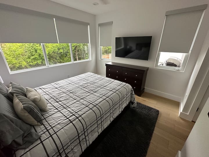 Dormitorio 1: cama tamaño queen en el nivel principal. El baño está contiguo. La vista es el patio trasero. 