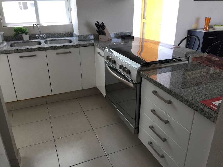 Cocina integral con horno convencional, microondas y refrigerador grande