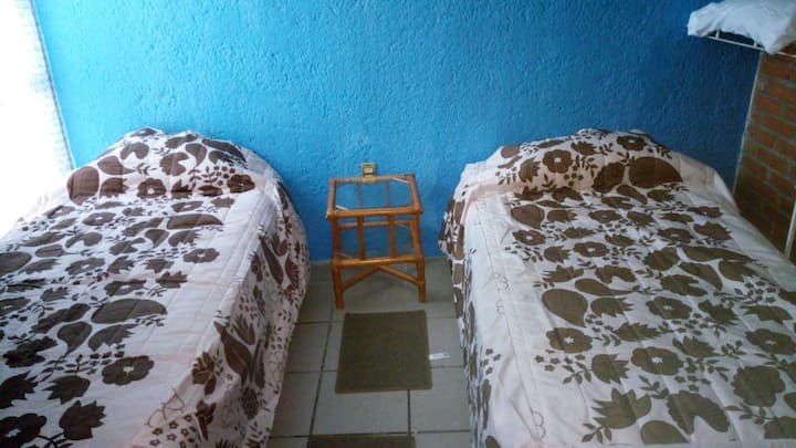 Segunda habitación con dos camas individuales, ventilador, sillón individual, plancha y burro de planchar, almohada y cobija extras.