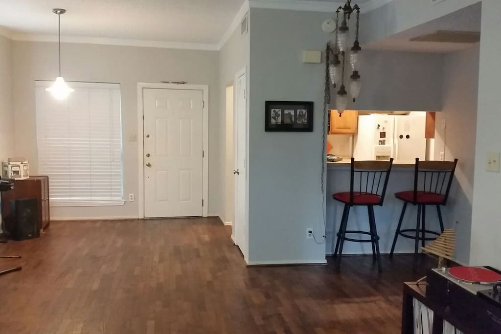 View of front door with kitchen and bar top on the right.