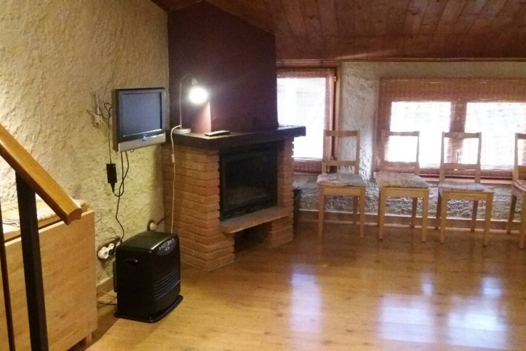 Salón comedor con chimenea y TV