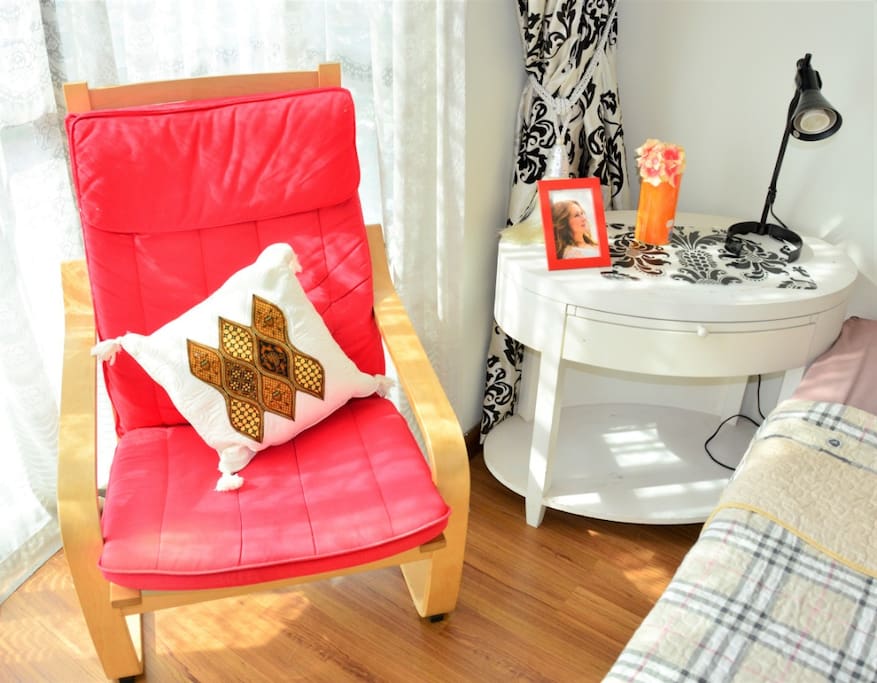 Bedside table and bedside lamp with single seater lounge chair, double layer curtain, sheer and thicker layer