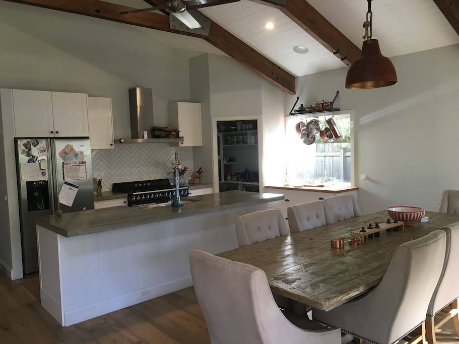 Concrete bench tops throughout with wooden preparation area. SMEG two door refrigerator/freezer, dishwasher, steam microwave, free standing cooker with gas cooktop and coffee machine.