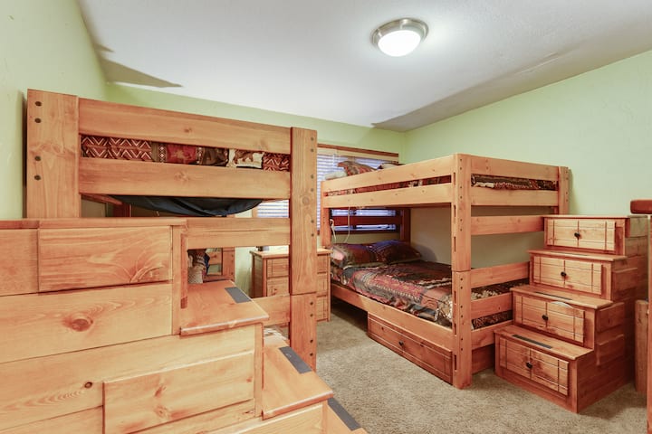 חדר שינה למטה עם דרגש מלא אחד ומיטה זוגית אחת