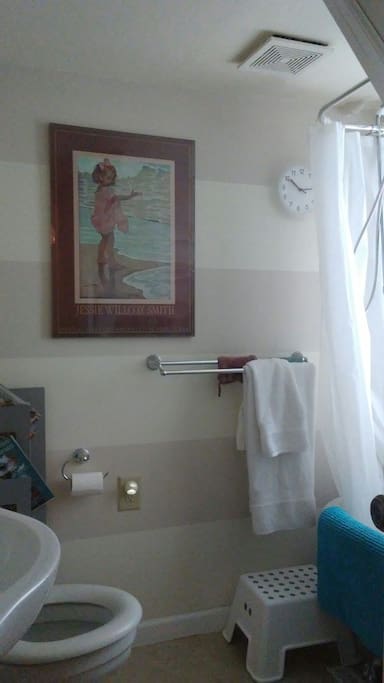 Bath with claw foot tub/shower, ample clean towels, and shelf space for toiletries.