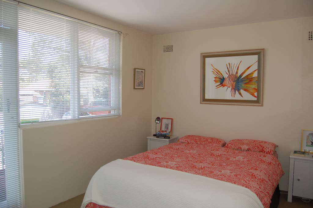 Bedroom with queen bed, desk and small balcony