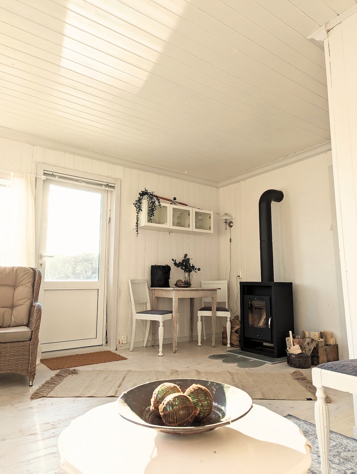 Una foto tomada desde el sofá hacia la chimenea y una mesa con sillas de comedor.