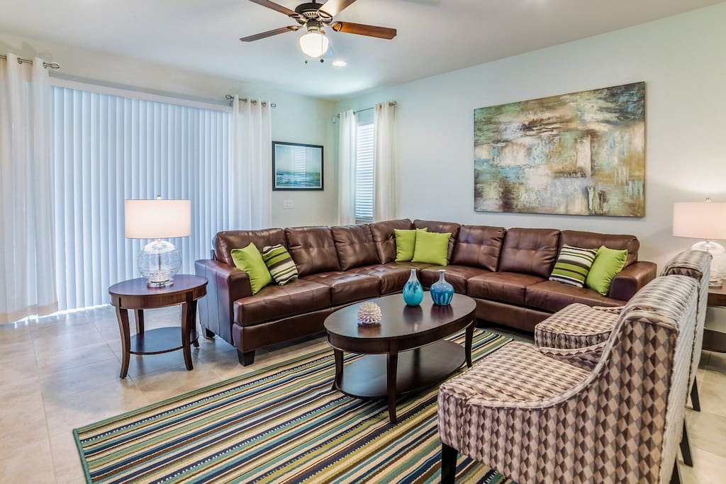 Living room with leather sectional sofa with easy access to the pool deck