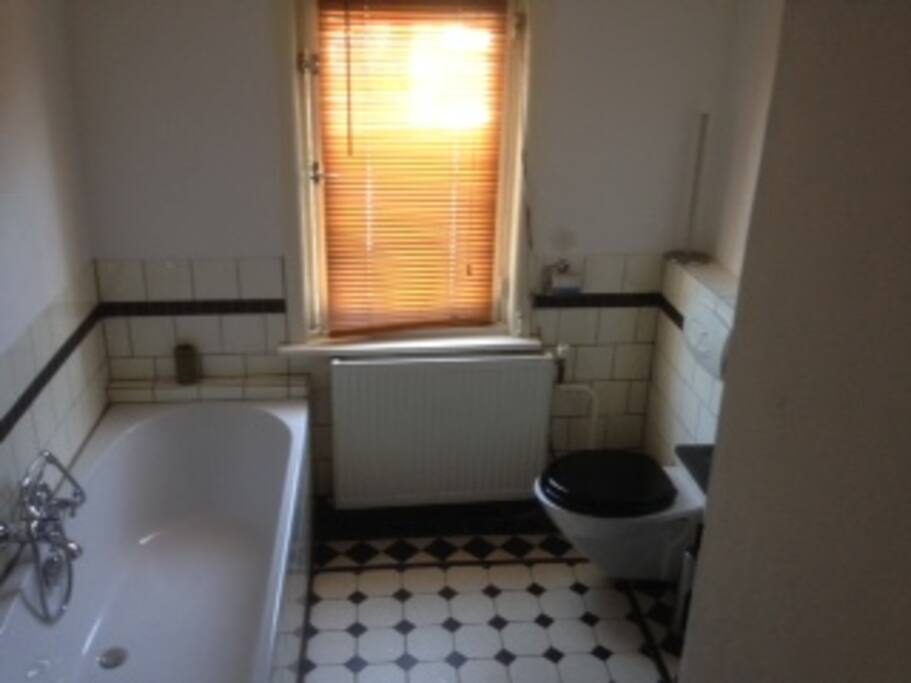 Bathroom with floorheating, bathtub, shower and toilet in the back