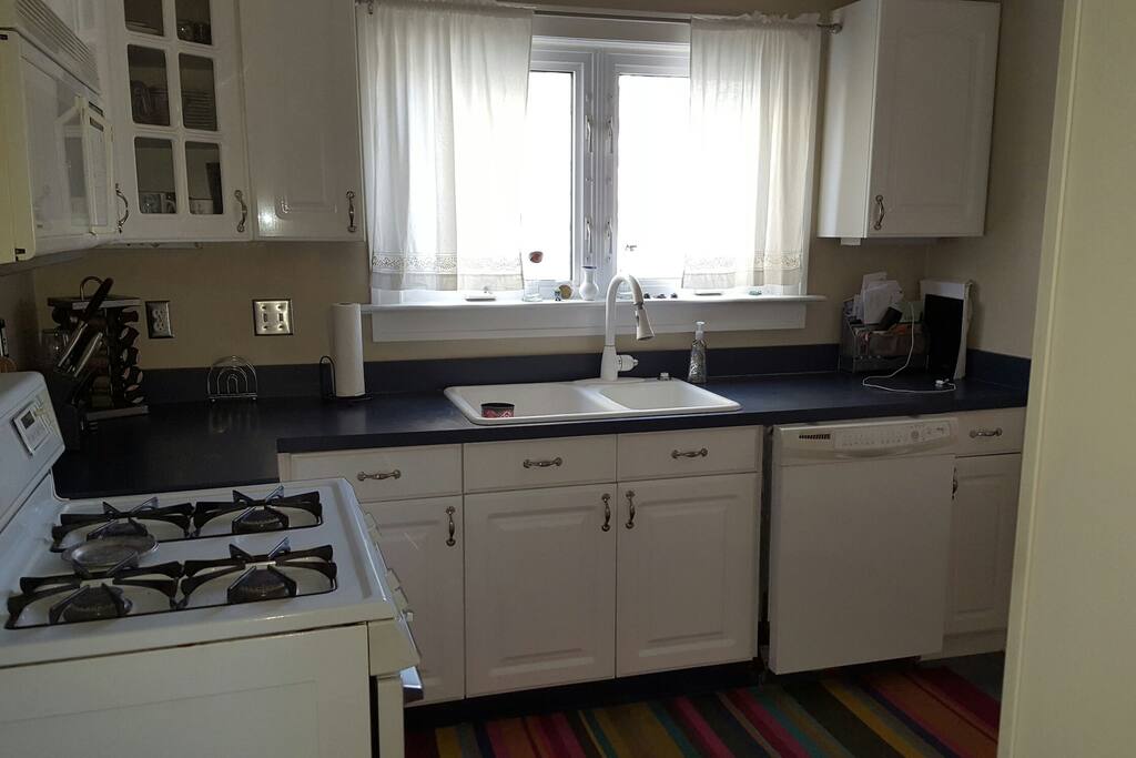 Fully equipped kitchen with back door that leads to fenced in yard.