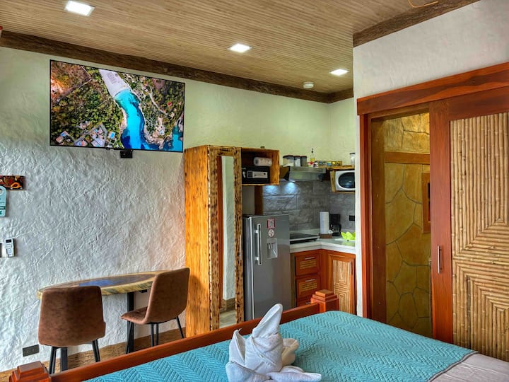 Elegante estudio romántico con cómoda cama tamaño king, colchón ortopédico, wifi, aire acondicionado potente, cocina pequeña, Smart TV, armario, baño completo, agua caliente en la ducha, caja de seguridad e impresionante vista frontal al jardín. Mesa interior y exterior con sillas.