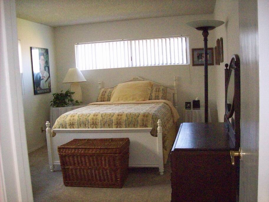 Furnished private bedroom in downstairs with desk, dresser, and closets.
