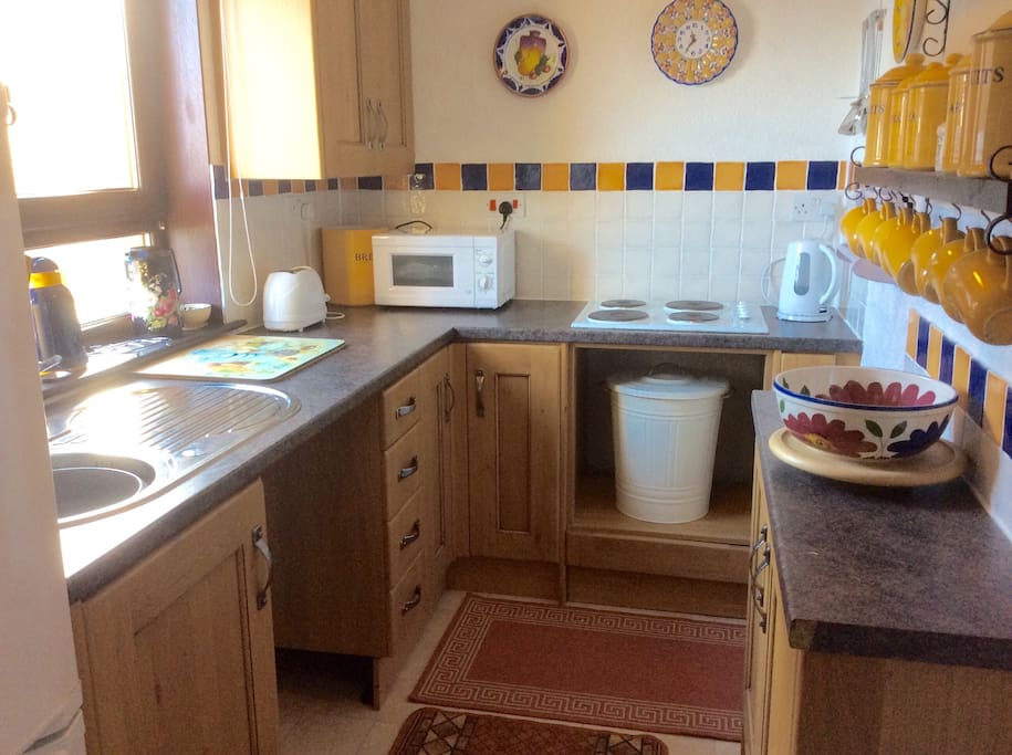 Our pretty little kitchen looks straight out to sea, it includes a fridge freezer, microwave oven, electric hob, a kettle and toaster with a good variety of pans and crockery.