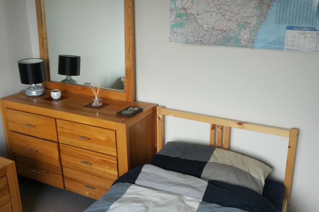 Bedroom with single bed, table, chair and builtin