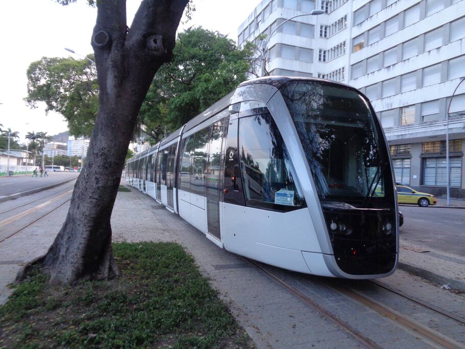 MODERNO TREM ELÉTRICO E SILENCIOSO PASSANDO EM FRENTE AO PRÉDIO