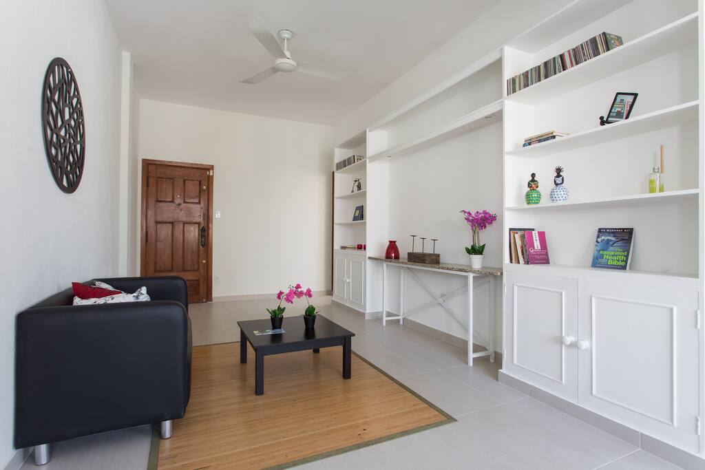 Large L shape living room with high ceilings, loads of lights and a cosy, inviting feeling.
