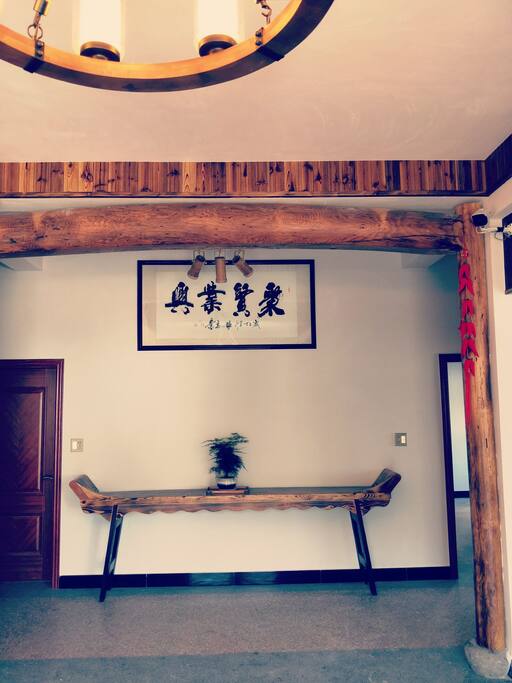进门大厅聚贤业兴是著名书法家张心志所写。房子都是以实木装修,此横梁是百年的老松木柱子是近60年的杉木