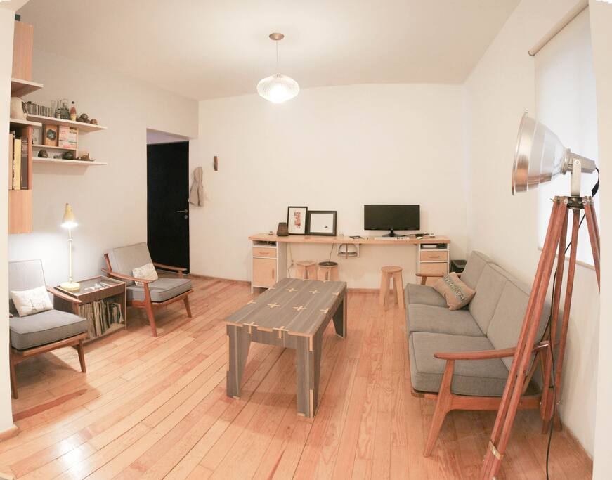 A scandinavian style living room shares space with a work area.
