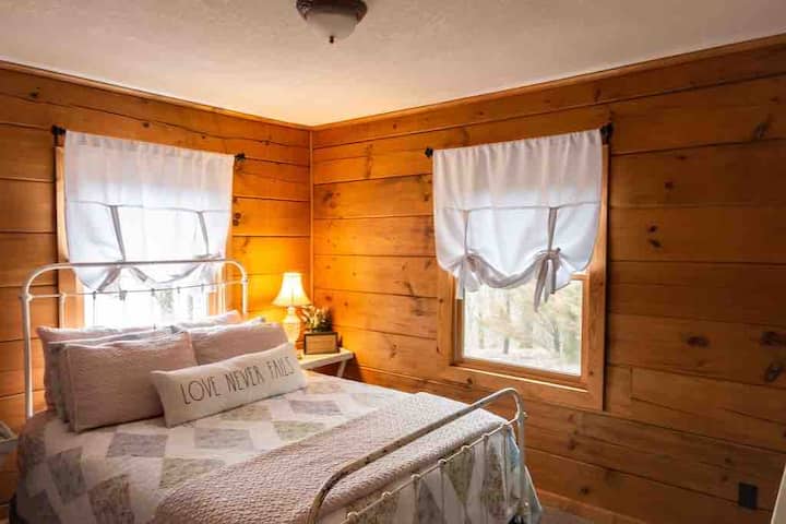 Dormitorio con cama tamaño queen y estructura de cama de hierro de barra antigua