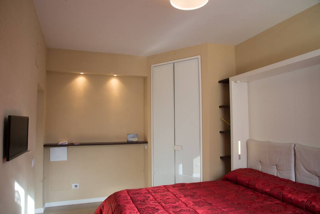 Ingresso, cabina armadio e letto.