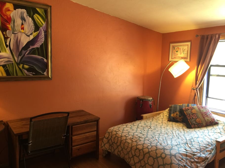 Comfy bed in a calm, cheerful room.