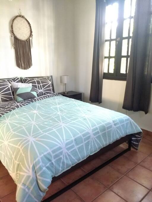 Bedroom with natural lighting, garden and street view.
