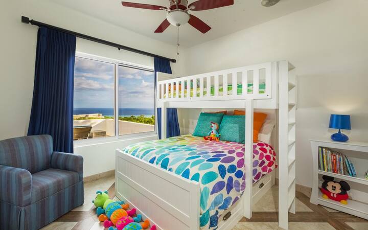 Queen/Twin Bunk-beds with stunning ocean view. A ceiling fan, air-conditioning, and black-out curtains guarantee a good nights sleep! 

This room has enough space for a full-size crib, pack'n'play or rollaway bed. It has an en-suite bathroom with tub