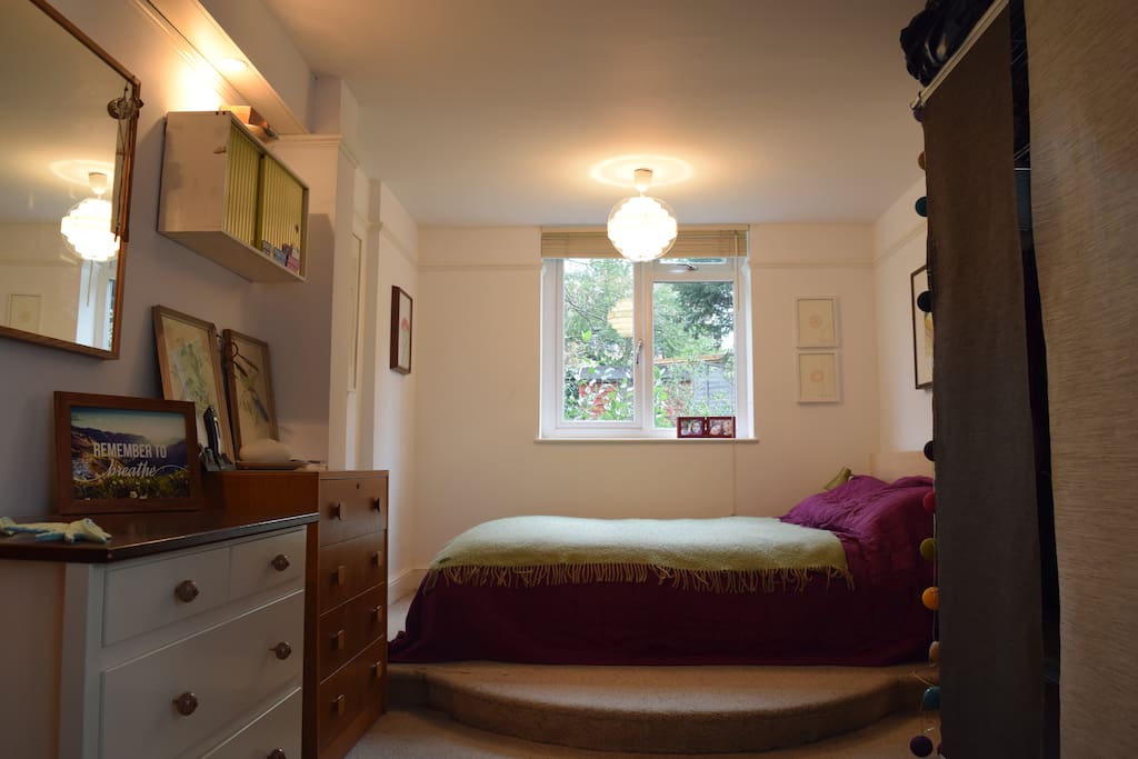 This is our large bedroom with a view of the back garden outside.
