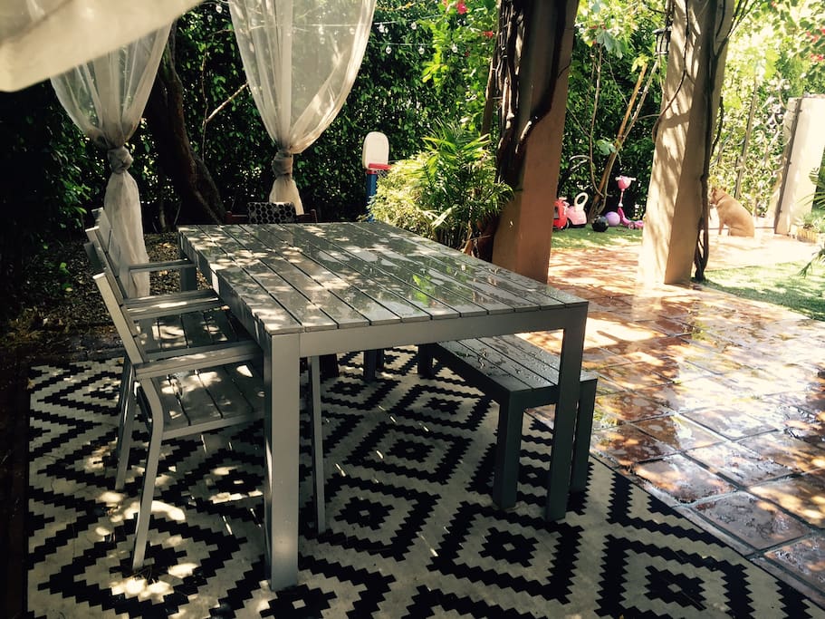 Outdoor dining table with privacy trees and gated. Can comfortably seat 4-6.