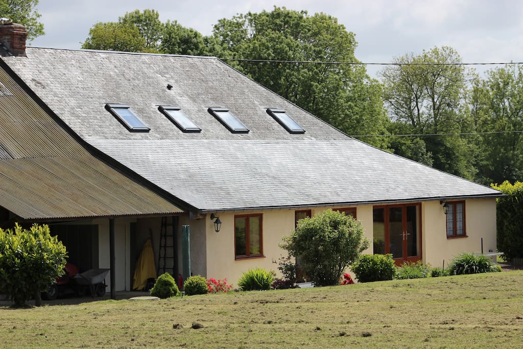 The sunny rear garden has a massive acre of grass with a sheltered patio and BBQ area near the house