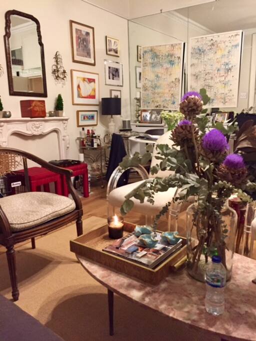 Living room features a distinct dining area, chic vintage and antique furniture, and a full-service kitchen.