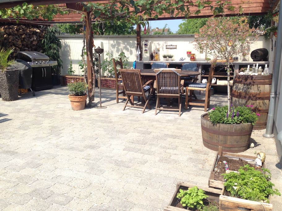 Outdoor dining area - room enough for 2 tables. 2 Barberque posibilities. At summer grapes are hanging from the roof :-)