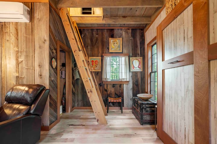 The treehouse is adorned with original art from Senegal and South Africa. The ladder leads to an upstairs sleeping loft and balcony. The cabinet reveals a queen-size bed with a comfy memory foam mattress and cotton linens.
Credit: Dickersonarts.com