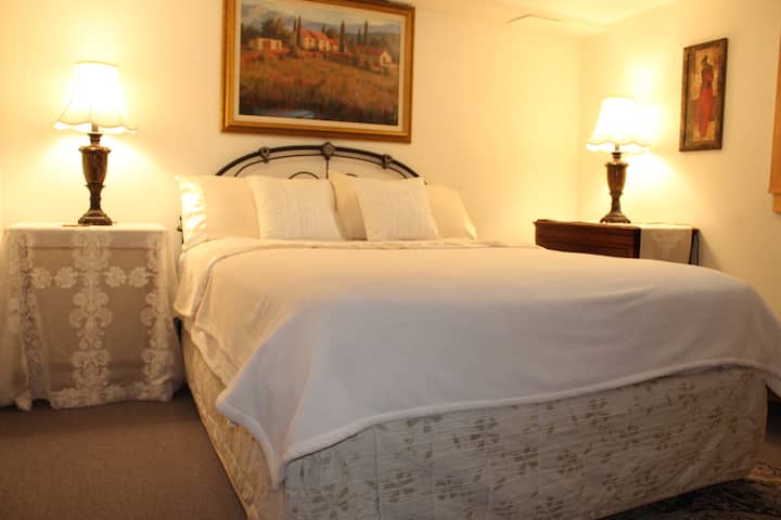A comfortable queen size bed in a large bedroom. 