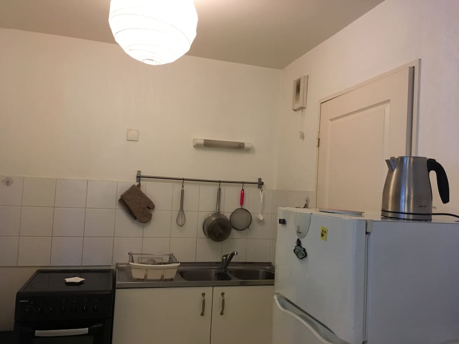 Cuisine tout équipée : plaque de cuisson, lave linge, frigo, congélateur, micro-ondes, four, machine à café, bouilloire.