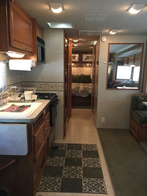 Motorhome features a full kitchen with oven/stove, microwave, and refrigerator/freezer.