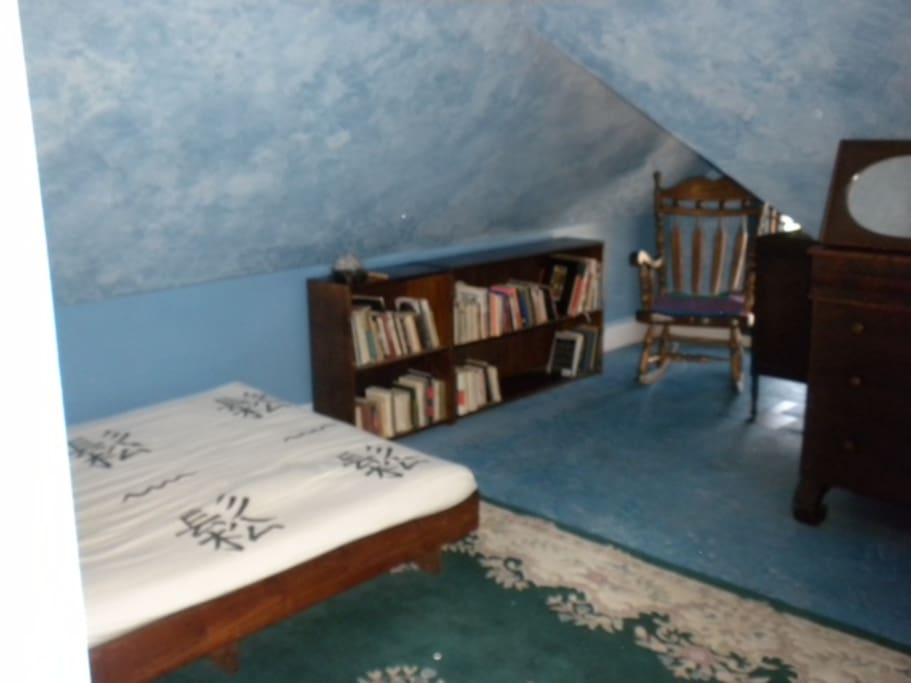 the bed, rug, rocking chair and dresser
