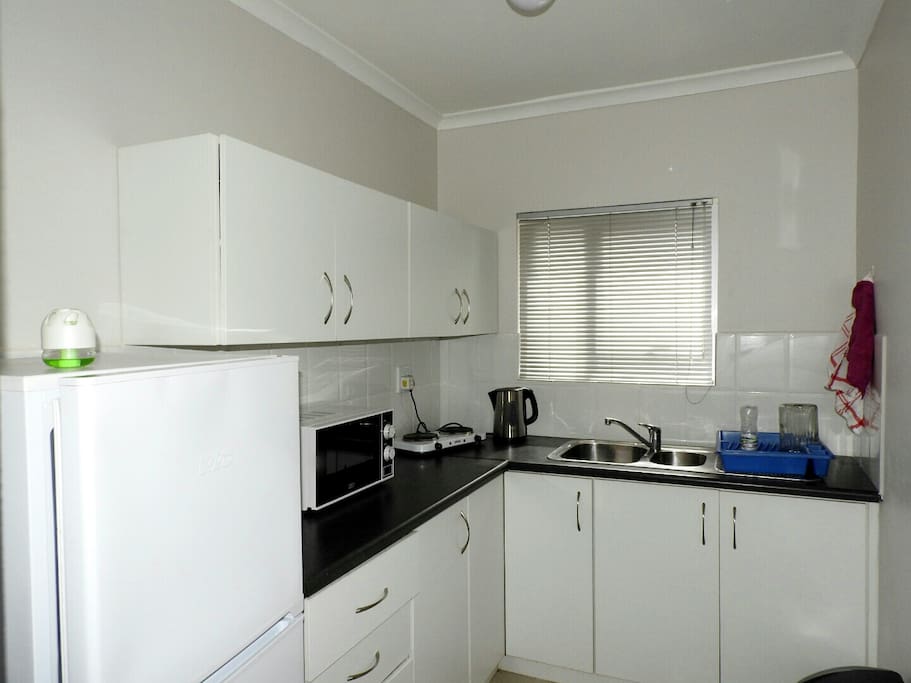 Kitchen with appliances.
Fridge, Kettle, Microwave, Toaster and small two plates stove.