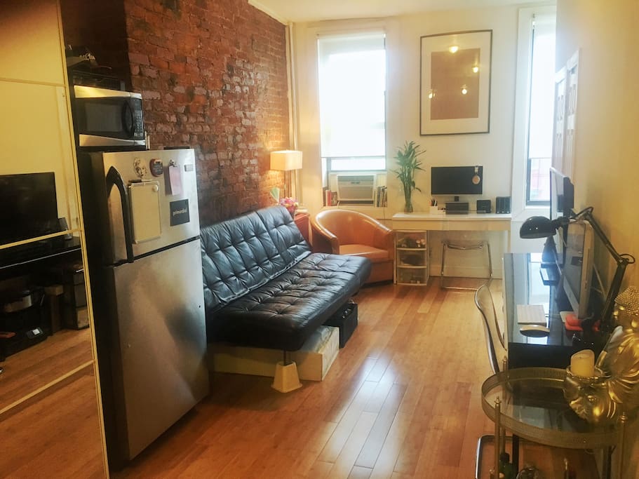 This is the living room area equipped with a TV (W/ HBO Go, Netflix, and Hulu). Also you can utilize our iMac. The couch pulls out into a double bed (we will provide blankets). This space also features a desk you can work at with an external monitor you can place your laptop into.