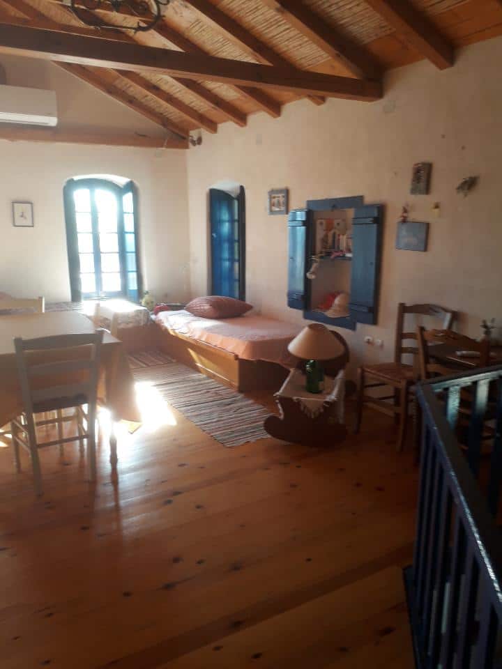 החדר הגדול, דלת מוארת וחלון המשקיפים על המרפסת והים