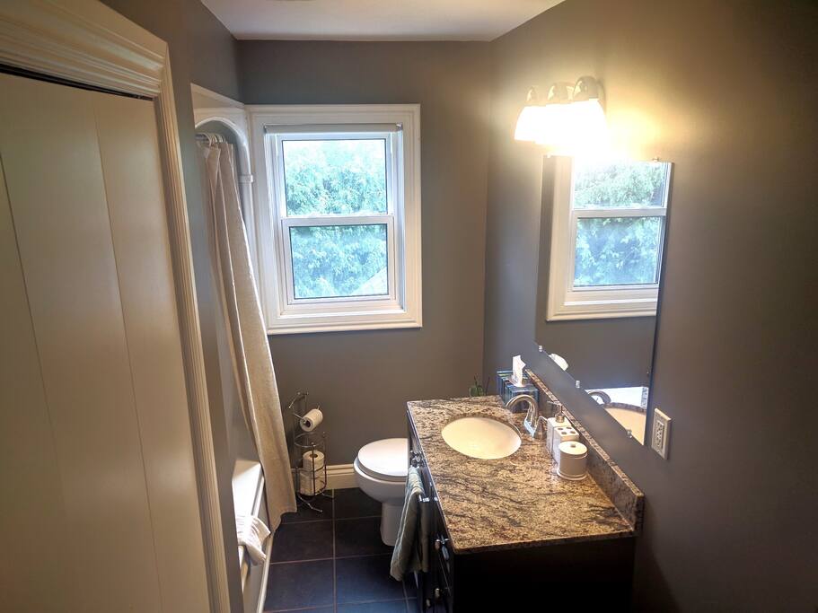 Full bathroom with granite countertops.