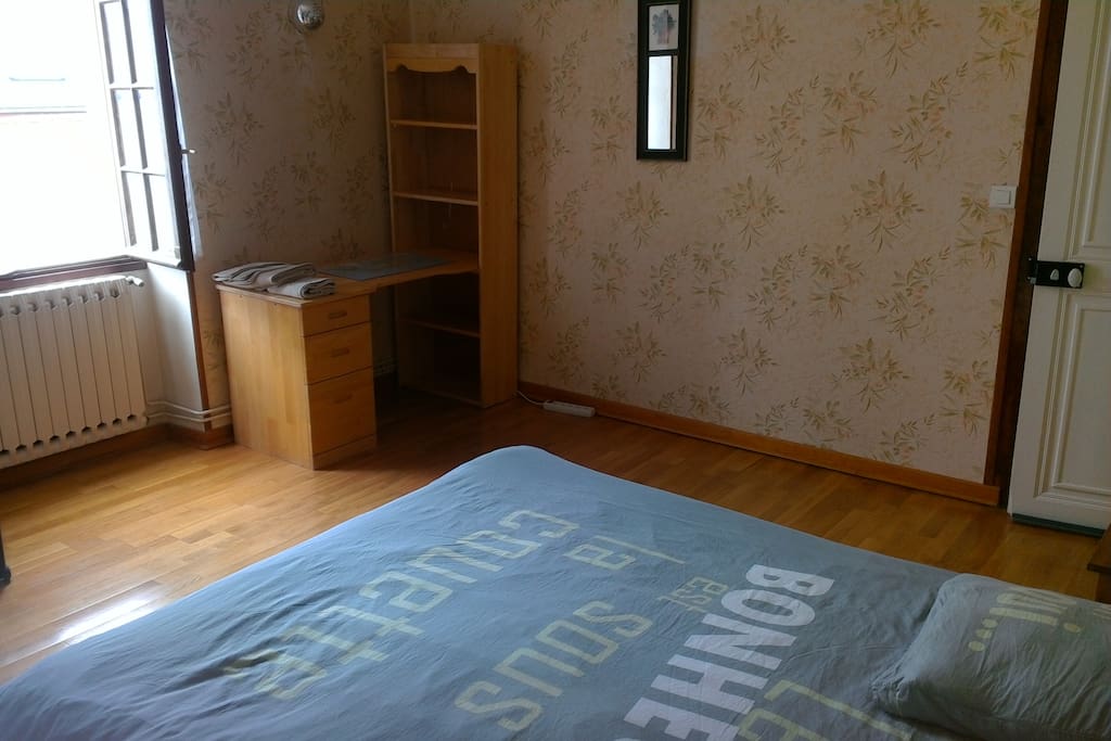 Une photo de la chambre avec le bureau.