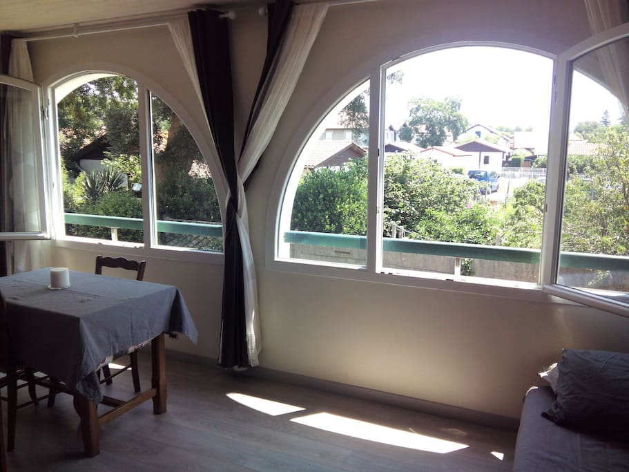 Grand balcon de 14 m² complétement isolé avec grande fenêtres donnant sur arbres et jardins, très calme. Un canapé lit pour deux personnes.